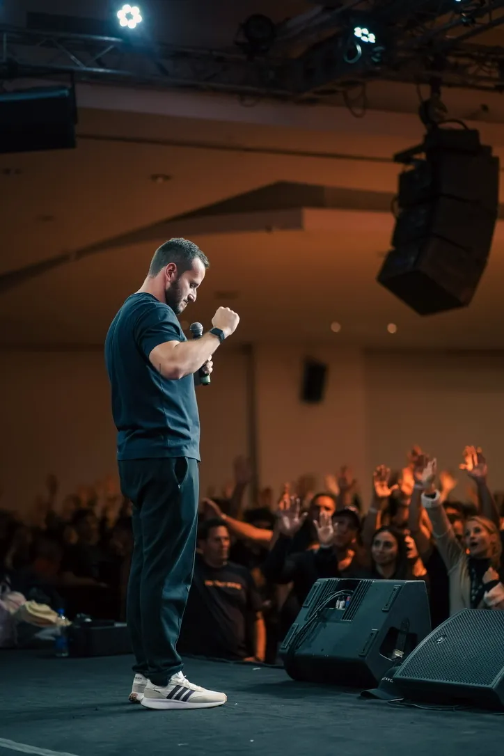 Alejandro Londoño en escena frente a un público con las manos en alto